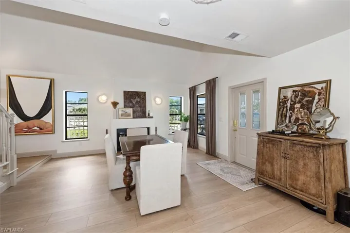 Dining space with light wood finished floors, stairway, recessed lighting, and a fireplace