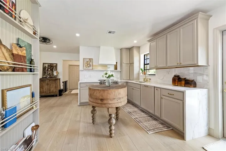 Kitchen featuring gray cabinets, stainless steel appliances, open shelves, decorative backsplash, and recessed lighting