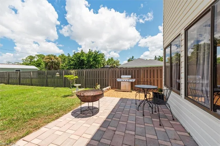 Back of property with a shingled roof, concrete driveway, a chimney, and a garage