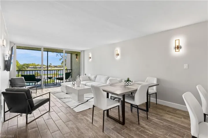 Modern living and dining room combination, thoughtfully furnished with brand new pieces and framed by tranquil lake views.