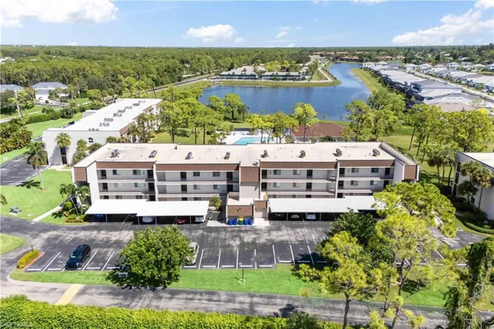 Expansive aerial shot capturing the quiet, well-kept neighborhood with inviting amenities and tranquil lakefront setting.