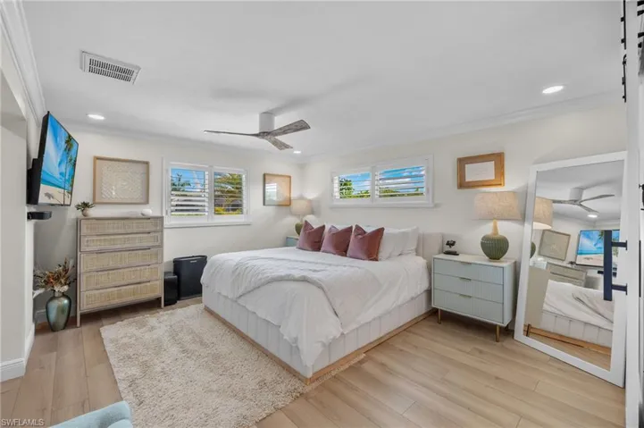 Bedroom featuring crown molding, light wood-style flooring, visible vents, ceiling fan, and recessed lighting