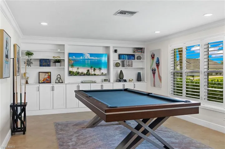 Playroom with crown molding, billiards, built in shelves, and visible vents
