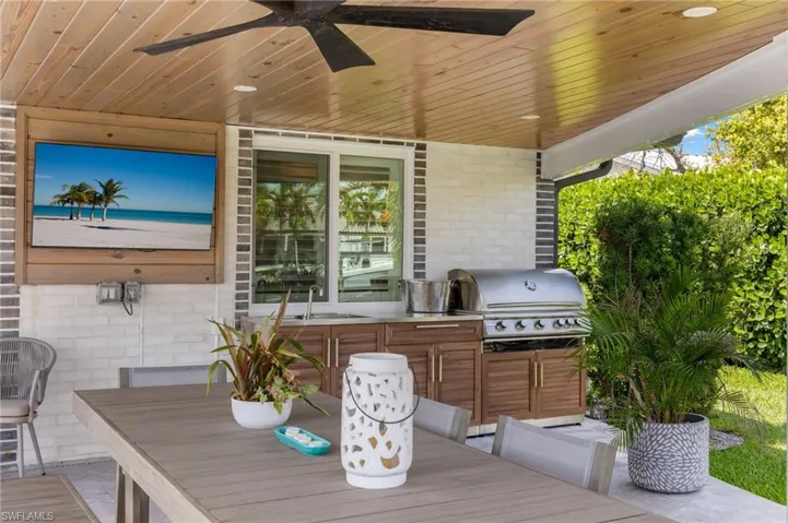 View of patio / terrace with a grill, a sink, outdoor dining space, and a ceiling fan