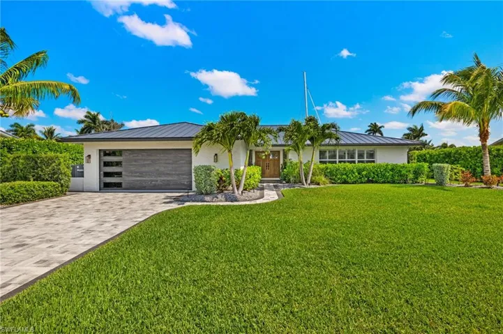 View of front of house featuring a standing seam roof, an attached garage, and metal roof