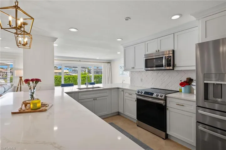 Kitchen with plenty of natural light, a sink, stainless steel appliances, and tasteful backsplash