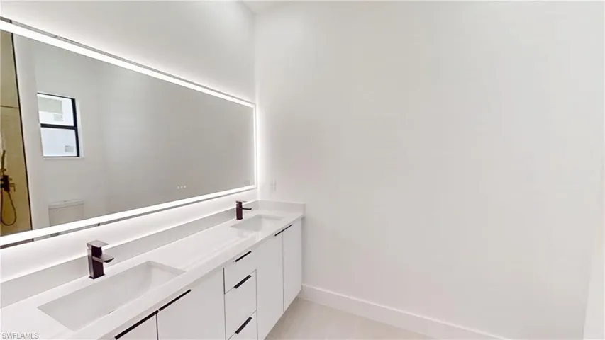 Full bath featuring double vanity and light tile patterned floors