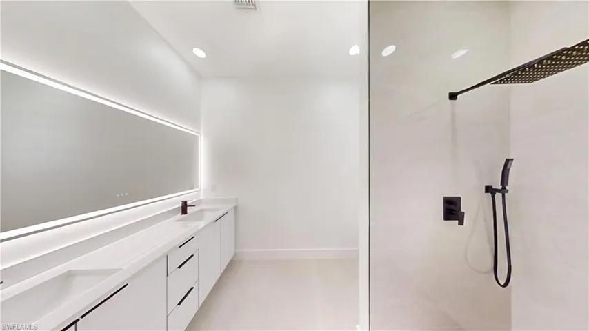 Full bath featuring double vanity, a walk in shower, and recessed lighting