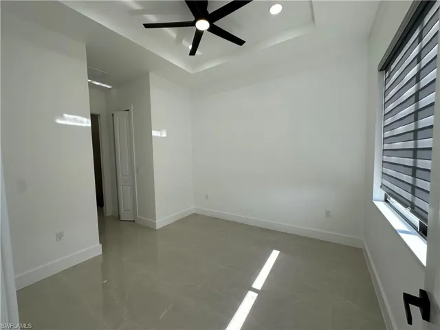 Unfurnished room featuring a tray ceiling and ceiling fan