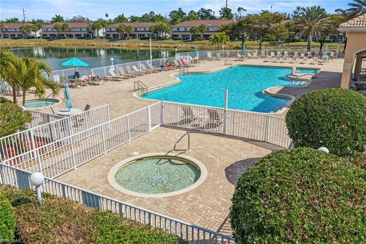 Community pool with a community hot tub, a patio, a residential view, and a water view