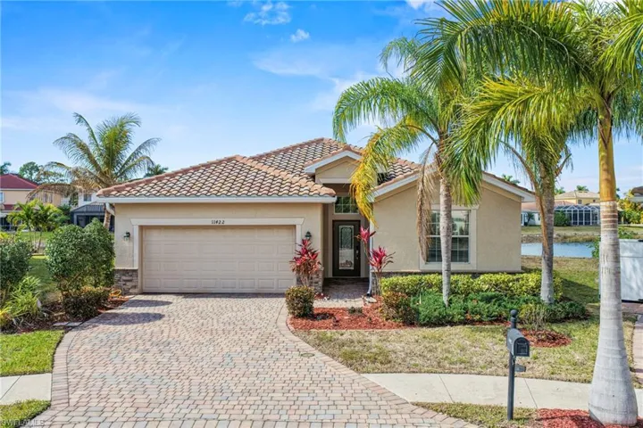View of front facade with stucco siding, an attached garage, decorative driveway, and a tiled roof