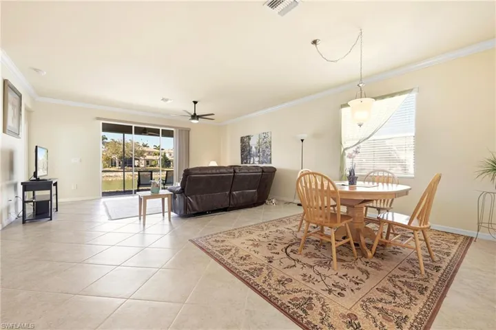 Dining area with ornamental molding, a ceiling fan, and light tile patterned flooring
