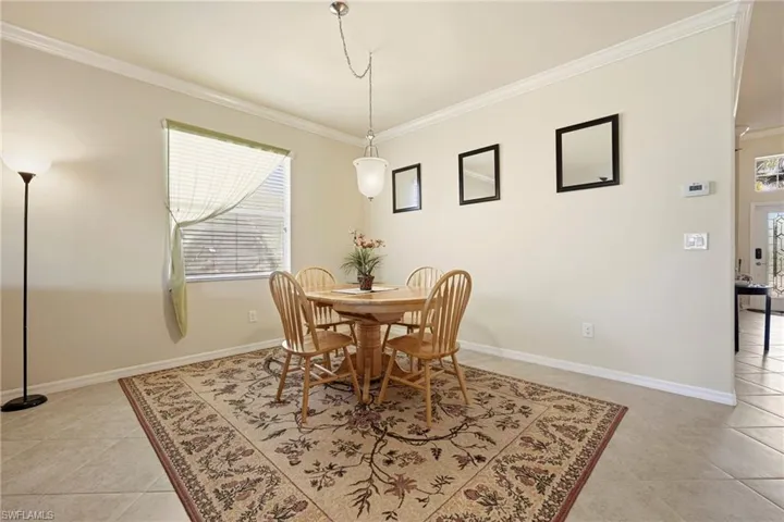 Dining space with ornamental molding and light tile patterned floors