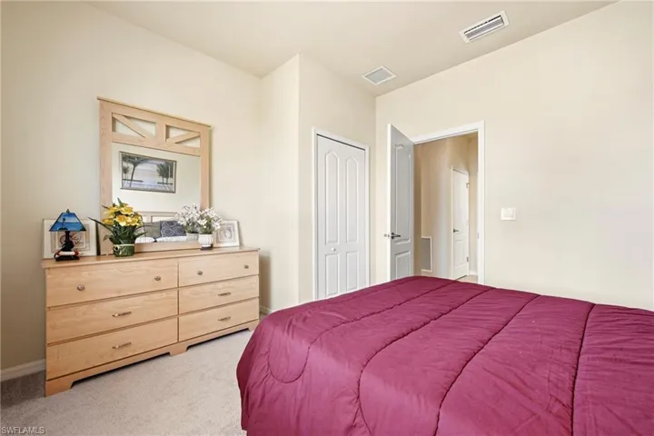 Bedroom featuring light colored carpet and a closet