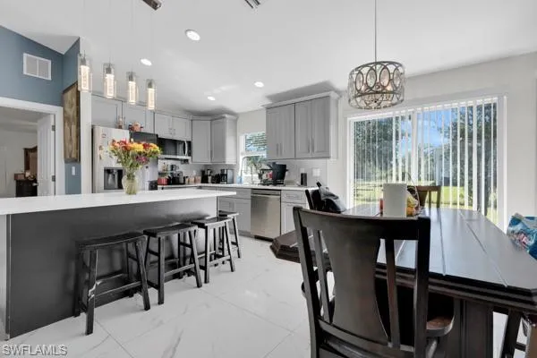 Dining room with light marble finish floors, recessed lighting, and a chandelier
