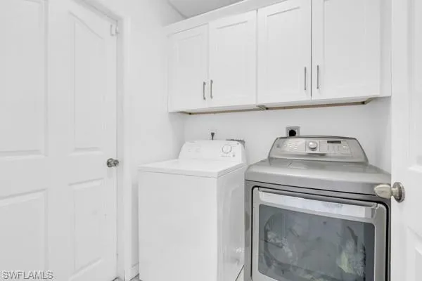 Laundry area featuring washer and dryer and cabinet space
