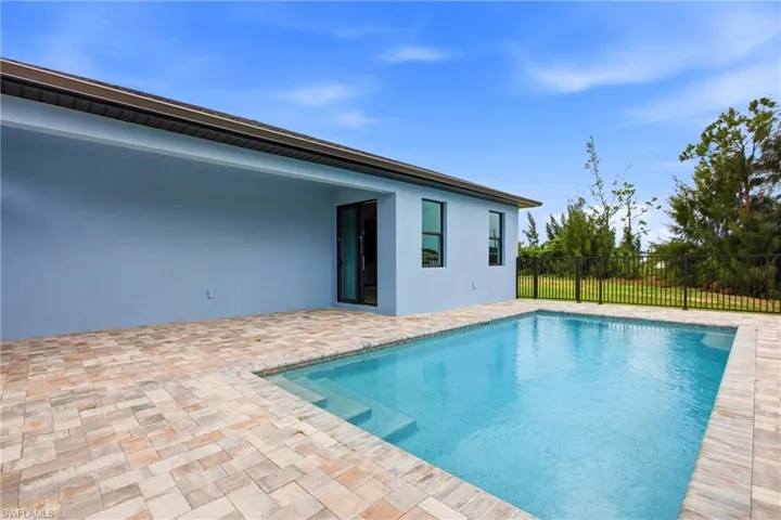 In-ground pool featuring built-in steps and surrounding paver patio