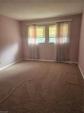 Carpeted empty room with a textured ceiling