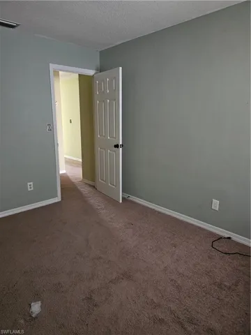 Empty room featuring carpet flooring and a textured ceiling