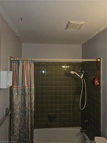 Bathroom with shower / bathtub combination with curtain