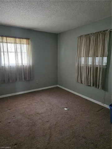 Carpeted empty room featuring a textured ceiling