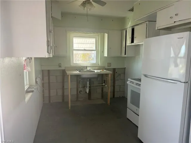 Kitchen with white stove & refrigerator