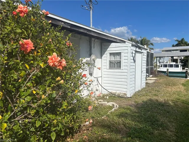 View of property exterior with a yard and an outdoor storage