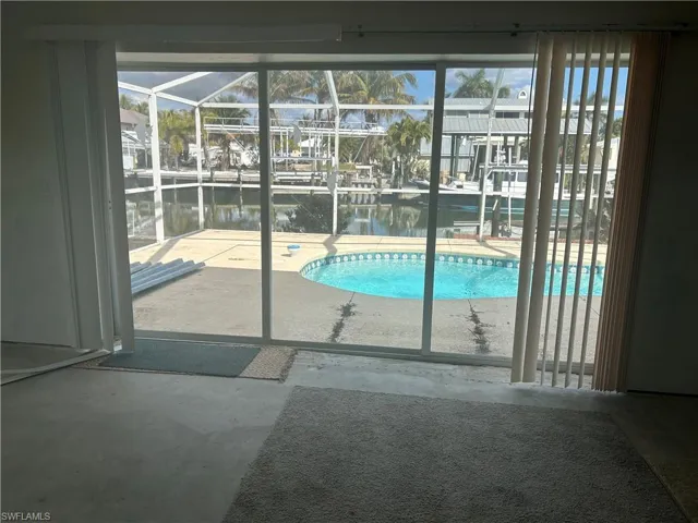 View of swimming pool with a water view and lanai
