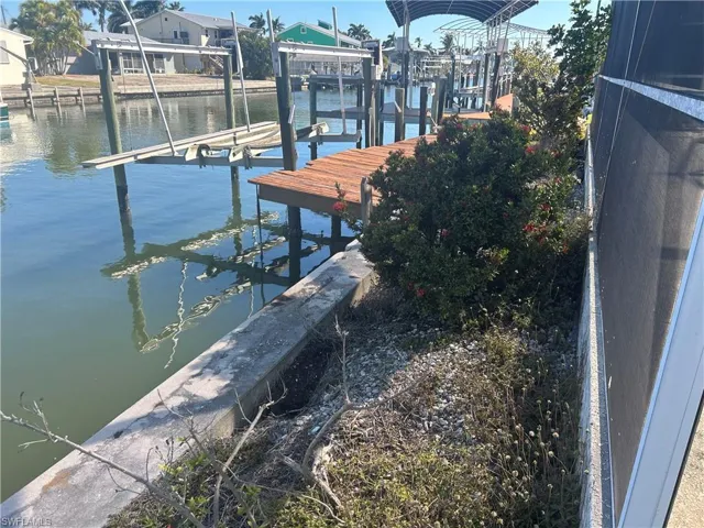 Dock area featuring boat lift and a water view