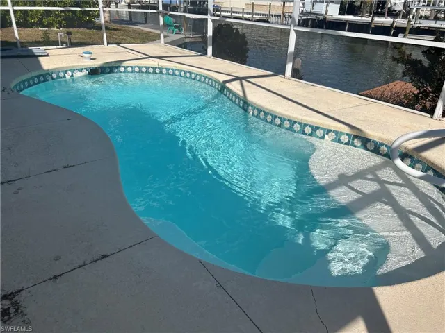 Outdoor pool featuring a lanai and a water view