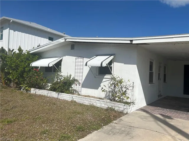 View of property exterior featuring stucco siding and a carport