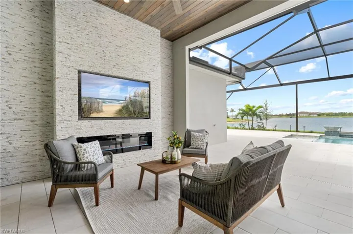 View of patio / terrace with a water view, pool water feature, an outdoor living space, and a lanai