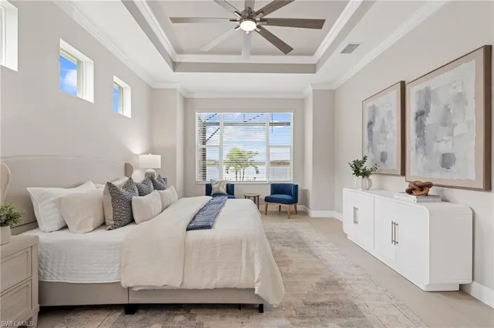 Bedroom featuring crown molding, ceiling fan, a tray ceiling, and light hardwood / wood-style floors