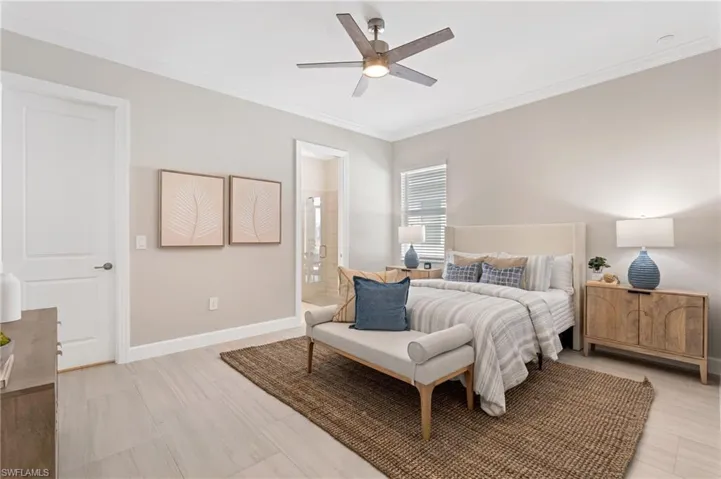 Bedroom with ornamental molding, ceiling fan, and ensuite bathroom