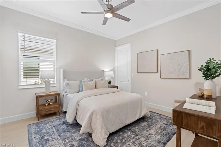Bedroom featuring ornamental molding, ceiling fan, and light wood-type flooring