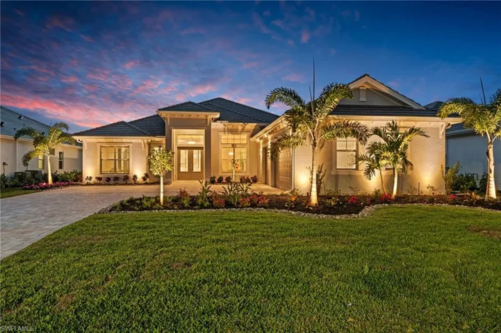 View of front of property with a garage and a lawn
