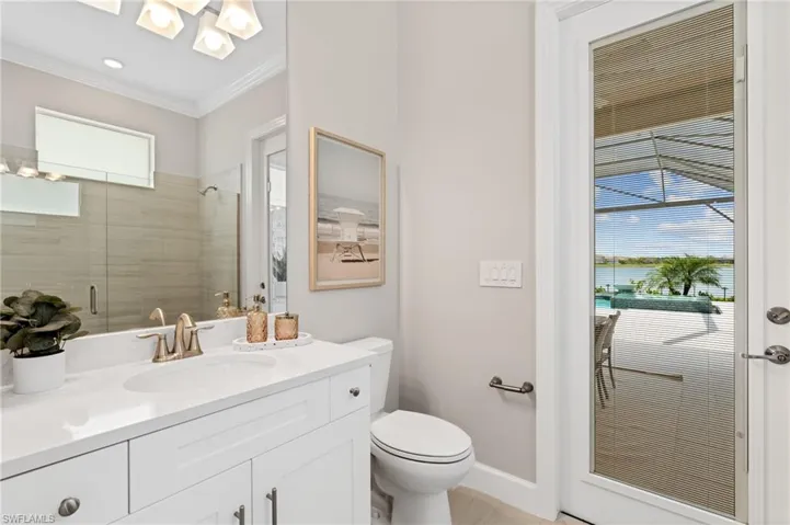 Bathroom featuring crown molding, vanity, an enclosed shower, and toilet