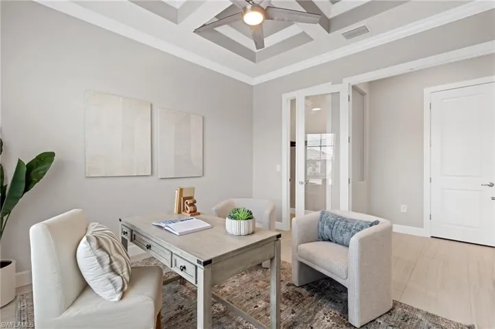 Office space with beamed ceiling, crown molding, coffered ceiling, and ceiling fan