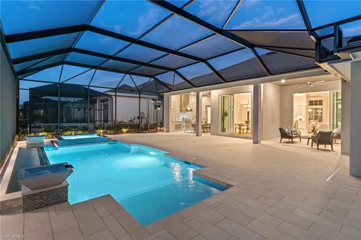 View of swimming pool with a patio, ceiling fan, glass enclosure, and a jacuzzi