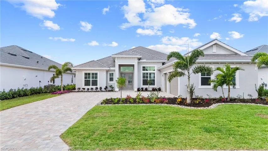 View of front facade featuring a garage and a front yard