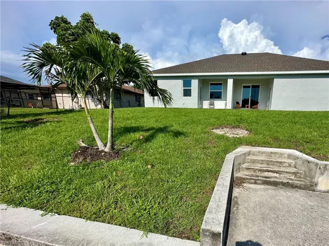 Rear view of property with stucco siding, roof with shingles, and a patio area