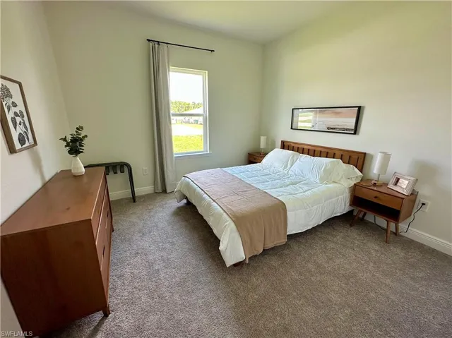 Bedroom featuring carpet and baseboards