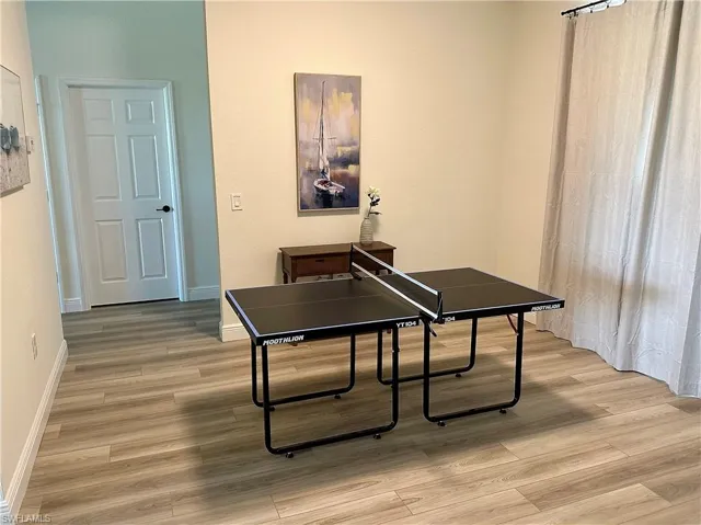 Recreation room with light wood-style floors and baseboards