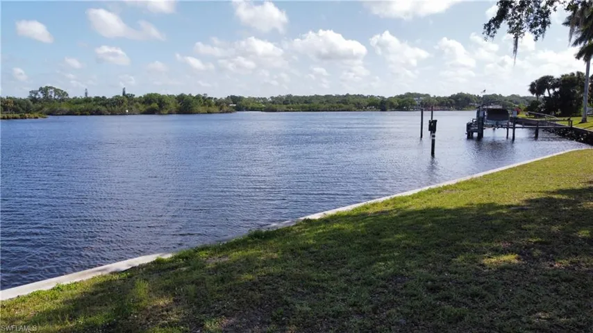 Water view featuring boat lift and a dock