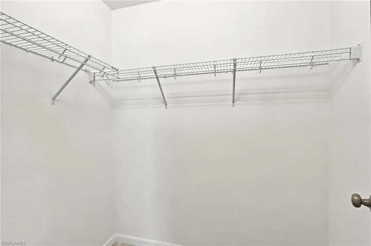 Storage area featuring white wall-mounted wire shelving and a circular door knob