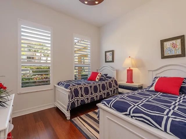 Bedroom with dark wood-style floors and baseboards
