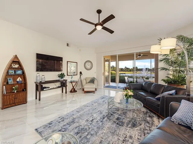 Living area with a ceiling fan and marble tiled flooring