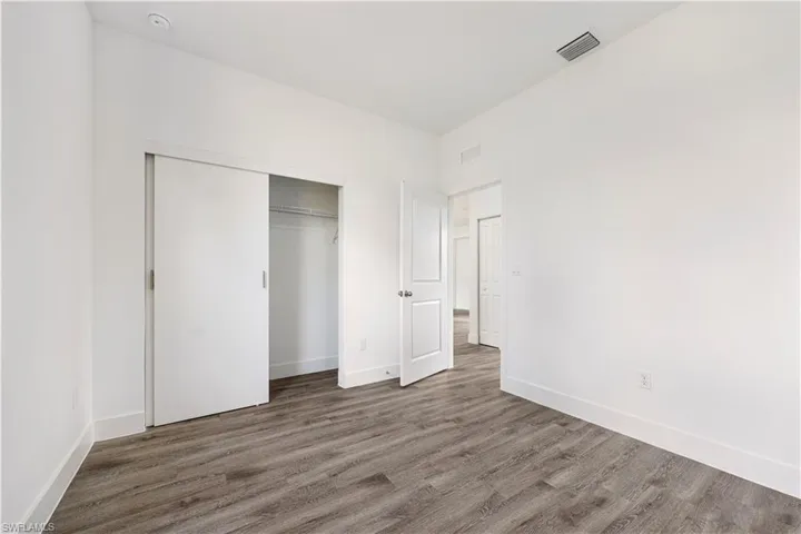 Unfurnished bedroom featuring wood finished floors and a closet