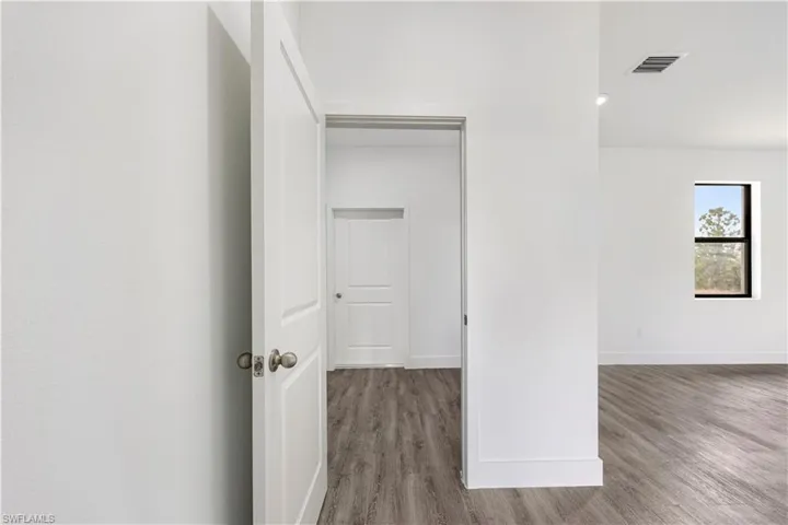 Hallway featuring light wood finished floors and baseboards