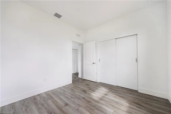 Unfurnished bedroom featuring a closet and wood finished floors